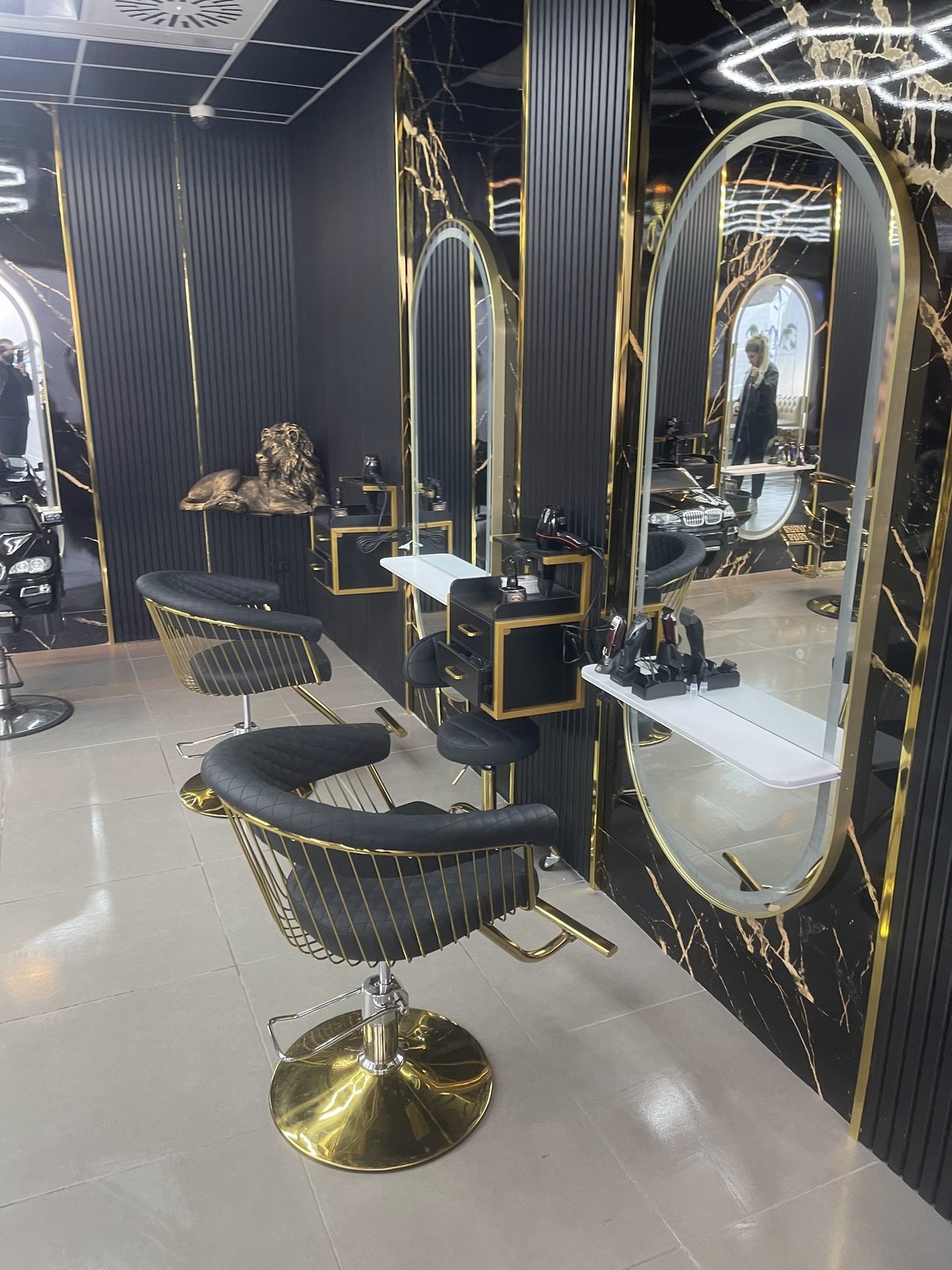 Zwarte stoelen met gouden frames voor de ovale spiegels