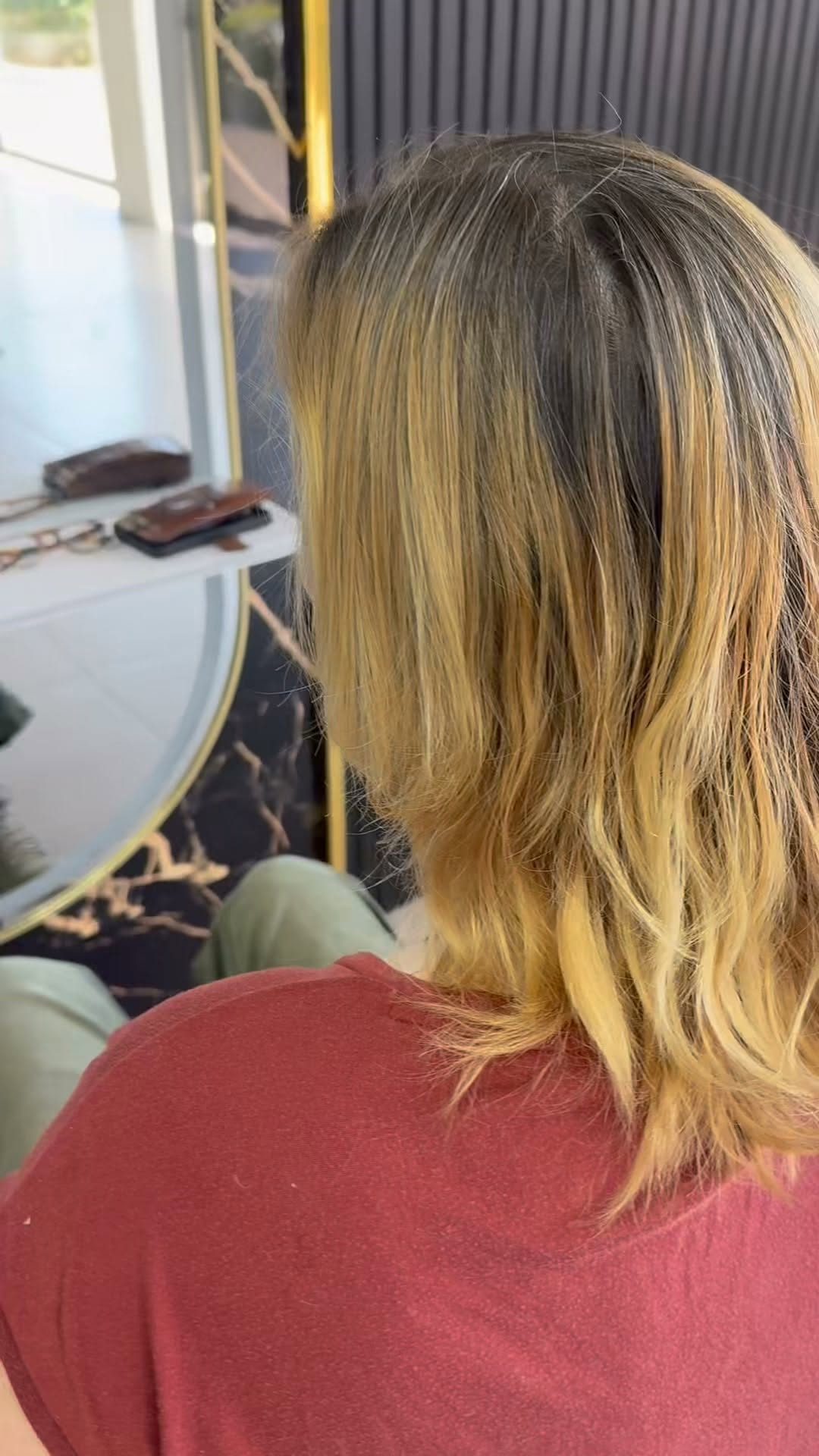 Blond haar met een warme zomerkleur, van achteren gezien in de salon